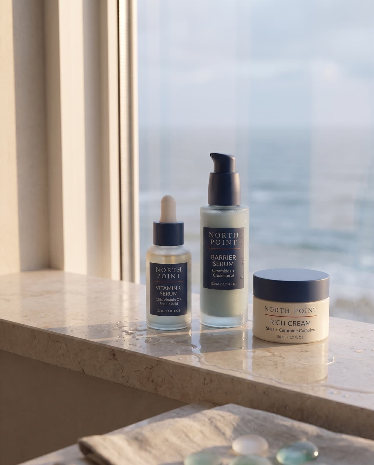 Vitamin C Serum, Barrier Serum and Rich Cream on a sunlit limestone windowsill above the sea